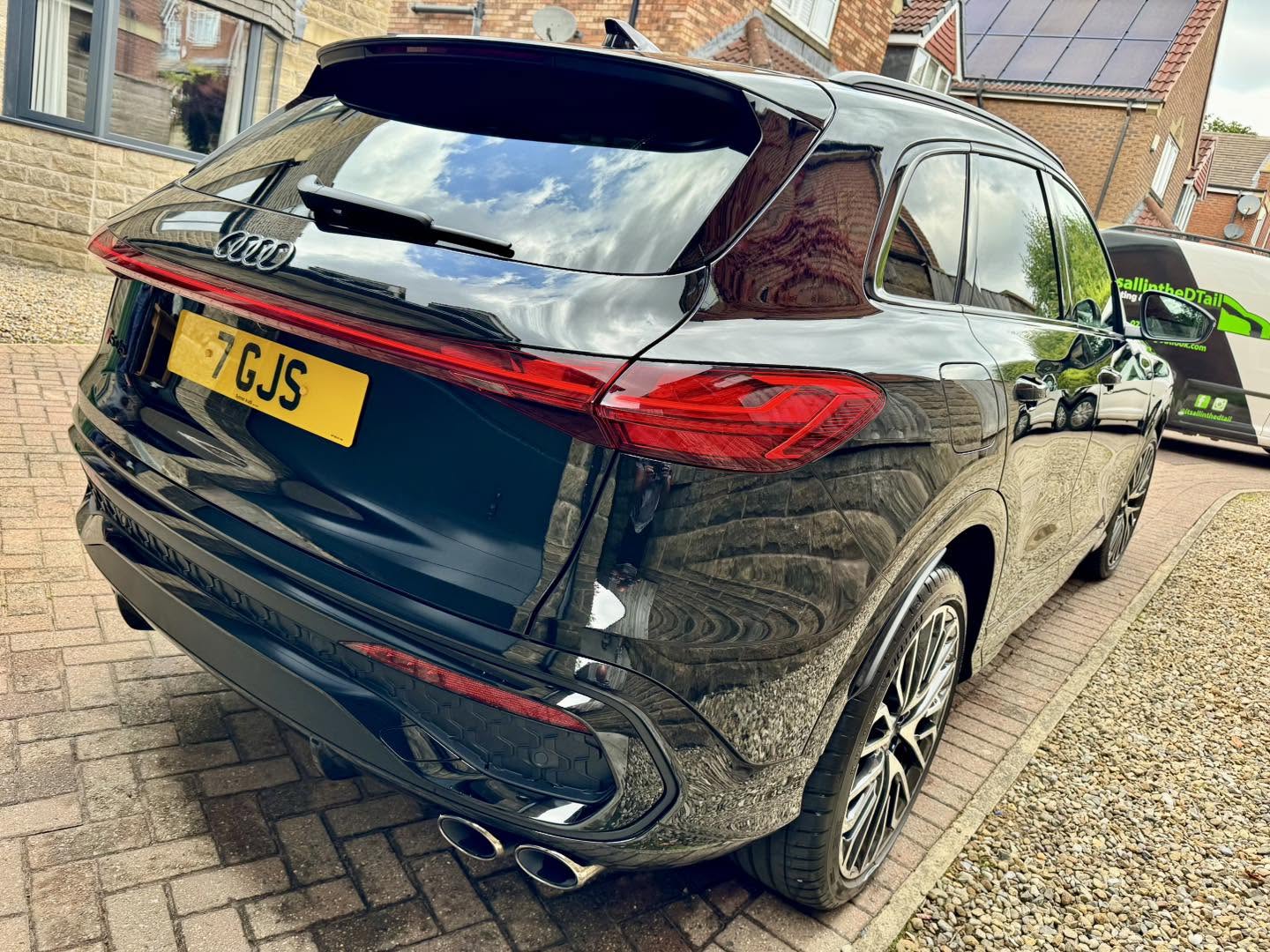 Black Audi Q6 e-tron rear quarter with mirror-like reflections